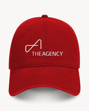 Load image into Gallery viewer, A red baseball cap, featuring a white embroidered logo that reads 'THEAGENCY'.