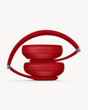 Load image into Gallery viewer, Folded Red over-ear wireless Bluetooth headphones with the Beats logo on the ear cup.