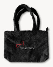Load image into Gallery viewer, Black Sherpa tote bag with 'The Agency' logo printed in white on one side.